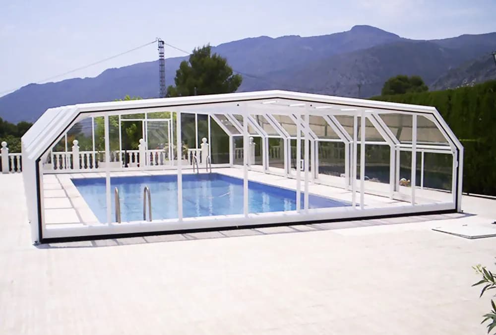 Cubierta alta acristalada sobre una piscina con vistas a la montaña
