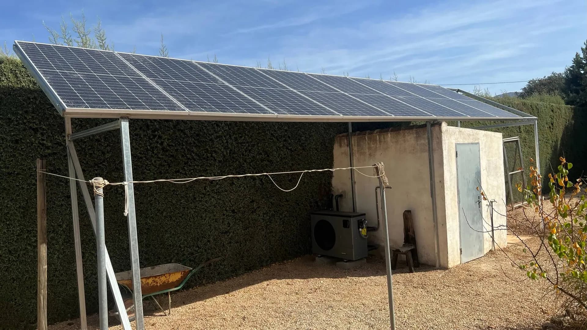 Paneles solares sobre pérgola exterior junto a una bomba de calor